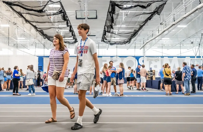 Two visitors walk inside the Wellness and Recreation center during an activity fair.